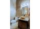 Elegant powder room featuring a vessel sink, decorative mirror, and stylish lighting fixture at 13627 E Monument Dr, Scottsdale, AZ 85262