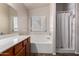 Bathroom featuring a large tub with shower and window for natural light at 1428 W Mesquite Ave, Apache Junction, AZ 85120