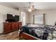 Bedroom with ceiling fan, window with blinds, and wooden dresser with television at 1428 W Mesquite Ave, Apache Junction, AZ 85120