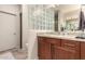 Modern bathroom features a marble countertop, wood cabinets, and unique glass block decor at 15050 N Thompson Peak Pkwy # 1035, Scottsdale, AZ 85260