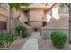 Condo building exterior featuring stucco walls, landscaped walkways, and stairs leading to upper-level units at 15050 N Thompson Peak Pkwy # 1035, Scottsdale, AZ 85260