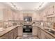 Well-lit kitchen with stainless steel appliances, stone countertops, and tile backsplash at 15050 N Thompson Peak Pkwy # 1035, Scottsdale, AZ 85260