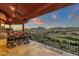 A covered patio features an outdoor dining area with sunset views of the golf course and desert landscape at 15106 E Miravista --, Fountain Hills, AZ 85268