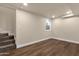Finished basement area featuring wood floors, a staircase, and a window for natural light at 1533 W Culver St, Phoenix, AZ 85007