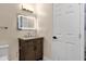 Bathroom showcasing a wood vanity with marble counters, an illuminated mirror, and a white door at 1533 W Culver St, Phoenix, AZ 85007
