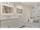 Elegant bathroom featuring a dual sink vanity, illuminated mirrors, and marble-tiled walls and floors at 1533 W Culver St, Phoenix, AZ 85007