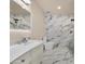 Bright bathroom showcasing a modern vanity, sleek toilet, and a shower with marble-style tiling at 1533 W Culver St, Phoenix, AZ 85007