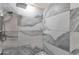 Shower with gray-patterned tiles, a rainfall shower head, and built-in storage shelves at 1533 W Culver St, Phoenix, AZ 85007