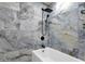 Shower-tub featuring gray-toned tiles, a sleek black shower head, and white finishes at 1533 W Culver St, Phoenix, AZ 85007