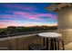 A balcony with table/chairs provides views of buildings, and sunset at 15802 N 71St St # 754, Scottsdale, AZ 85254