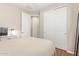 Bright bedroom with wood-look floors, featuring a bed, closet, and access to hallway at 16658 W Mescal St, Surprise, AZ 85388