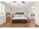 Comfortable bedroom with wood-look floors and a ceiling fan; view to bathroom at 16658 W Mescal St, Surprise, AZ 85388