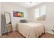Cozy bedroom with wood-look floors, neutral walls and a colorful piece of artwork at 16658 W Mescal St, Surprise, AZ 85388