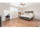 Cozy bedroom with wood floors, ceiling fan, a vanity table, and window with plantation shutters at 16658 W Mescal St, Surprise, AZ 85388