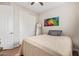 Bedroom featuring a closet with sliding doors, wood-look floors and colorful wall art at 16658 W Mescal St, Surprise, AZ 85388