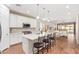Modern white kitchen with stainless steel appliances, kitchen island, and wood flooring at 16658 W Mescal St, Surprise, AZ 85388