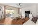 Bright living room featuring hardwood floors, a ceiling fan, and sliding glass doors to the patio at 16658 W Mescal St, Surprise, AZ 85388