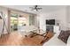 Bright living room with sliding glass doors leading to a patio, flat screen tv, and wood flooring at 16658 W Mescal St, Surprise, AZ 85388
