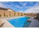 Modern swimming pool with a Baja shelf, water feature, and easy access to the yard at 16658 W Mescal St, Surprise, AZ 85388