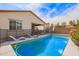 Sparkling pool with lounge chairs, mature trees and patio create a backyard oasis at 16658 W Mescal St, Surprise, AZ 85388