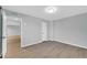 This is a vacant bedroom with wood-look floors and a door to another room at 17022 N Pinion Ln, Sun City, AZ 85373