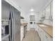 Kitchen with stainless steel appliances, white cabinets, and access to laundry room at 17022 N Pinion Ln, Sun City, AZ 85373