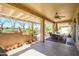 An inviting covered patio with ceiling fan, dining set, and outdoor seating area at 19212 N Tallowood Way, Surprise, AZ 85387