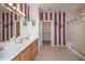 Spacious bathroom with double sinks, tiled floor, and shower with glass door at 19212 N Tallowood Way, Surprise, AZ 85387