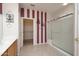 Well-lit bathroom with tiled floors, shower with glass doors, and a walk-in closet at 19212 N Tallowood Way, Surprise, AZ 85387
