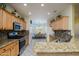 Bright kitchen featuring granite countertops, stainless steel appliances, and a view of the dining area at 19212 N Tallowood Way, Surprise, AZ 85387