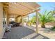 This home includes a covered patio with dining set and beautiful backyard landscaping at 19212 N Tallowood Way, Surprise, AZ 85387