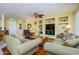 Inviting living room featuring comfortable seating, custom built-ins, and hardwood floors at 19212 N Tallowood Way, Surprise, AZ 85387