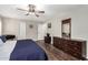 Bright bedroom features wood floors, a ceiling fan, neutral walls, and plantation shutters for natural light at 2046 E Avenida Del Sol --, Phoenix, AZ 85024