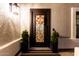 Close up on front door with floral decor, striped mat and potted plants at 2046 E Avenida Del Sol --, Phoenix, AZ 85024