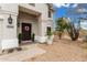 Inviting front porch featuring a decorative door, desert landscaping, and warm lighting at 2046 E Avenida Del Sol --, Phoenix, AZ 85024
