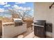 Grill area with a built-in gas grill and smoker on a tiled base near a low block fence at 2046 E Avenida Del Sol --, Phoenix, AZ 85024