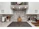 Modern kitchen details featuring a sleek cooktop, stainless steel hood, and attractive subway tile backsplash at 2046 E Avenida Del Sol --, Phoenix, AZ 85024