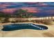 Backyard pool with perimeter lighting, desert landscaping, and lush palm trees at 2046 E Avenida Del Sol --, Phoenix, AZ 85024