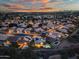 Night aerial view of a desert neighborhood and lit swimming pools with city lights in the distance at 22043 N 59Th Dr, Glendale, AZ 85310