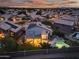 Aerial view of a home with a backyard pool, covered patio, and solar panels at dusk at 22043 N 59Th Dr, Glendale, AZ 85310