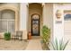 Front entryway with a decorative wrought iron door, arched alcove, and manicured landscaping at 22043 N 59Th Dr, Glendale, AZ 85310