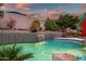 Close-up of a backyard pool with waterfall feature and desert landscaping at 22043 N 59Th Dr, Glendale, AZ 85310