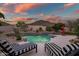 Beautiful backyard pool with a small waterfall feature, desert landscaping, and lounge chairs at 22043 N 59Th Dr, Glendale, AZ 85310