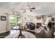 Comfortable living room with a stone fireplace, a ceiling fan, sliding glass doors leading to the backyard, and dark wood flooring at 2218 E Mallard Ct, Gilbert, AZ 85234