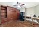 Home office featuring built-in shelves, a Murphy bed, desk space, and hardwood flooring at 2318 W Hedgehog Pl, Phoenix, AZ 85085