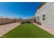 Expansive backyard features an artificial grass lawn and patio perfect for outdoor relaxation and entertainment at 2475 W Spaulding Ave, Apache Junction, AZ 85120