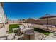 Inviting backyard featuring a cozy seating area with a fire pit, artificial turf, and a shaded dining table at 2475 W Spaulding Ave, Apache Junction, AZ 85120