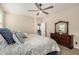 Comfortable primary bedroom features a ceiling fan, plush carpet, and dresser with mirror at 2475 W Spaulding Ave, Apache Junction, AZ 85120