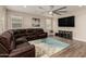 Spacious living room featuring wood floors, a large sectional couch, and a modern ceiling fan at 2475 W Spaulding Ave, Apache Junction, AZ 85120