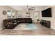 Spacious living room featuring wood floors, a large sectional couch, and a modern ceiling fan at 2475 W Spaulding Ave, Apache Junction, AZ 85120
